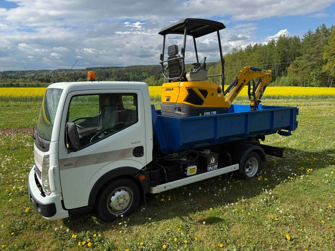Kontejnerové auto s naloženým minibagrem